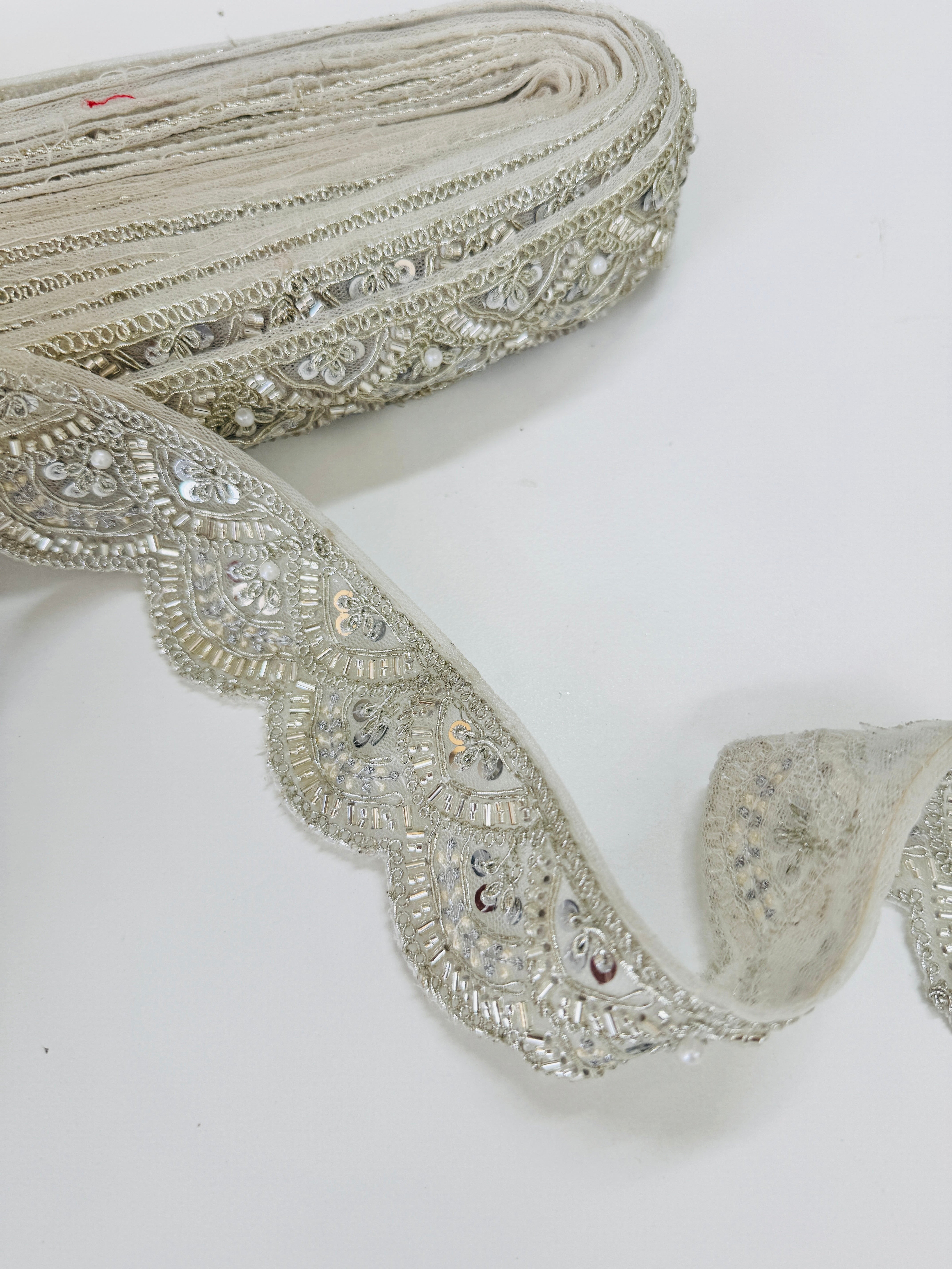 Ivory pearl beaded scalloped lace trim with intricate embroidery, sequins, and pearl embellishments for bridal gowns, veils, sarees, lehengas, christening dresses, and couture sewing projects.