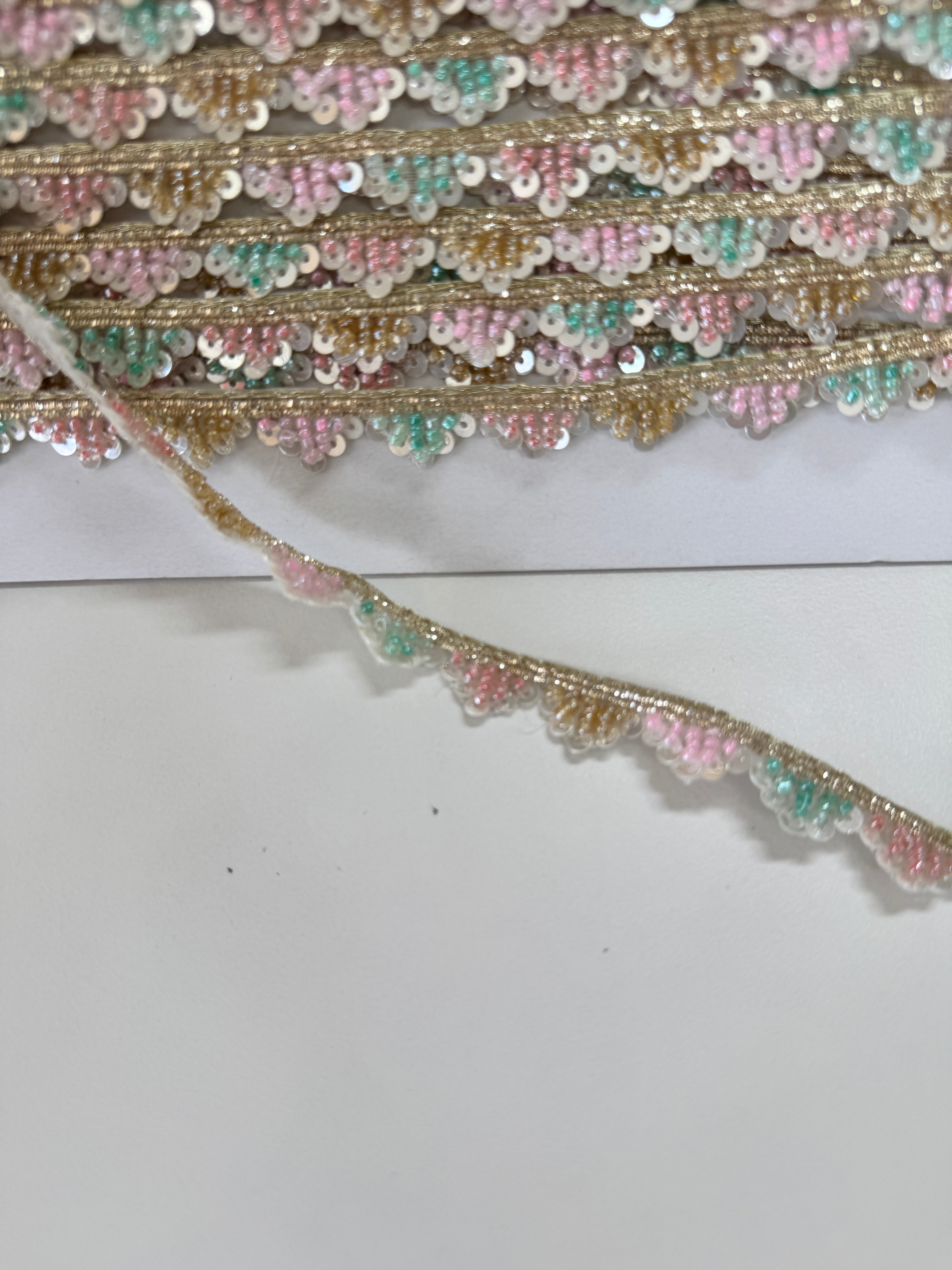 Pastel pink, mint, ivory, and gold beaded sequin trim with metallic edging.