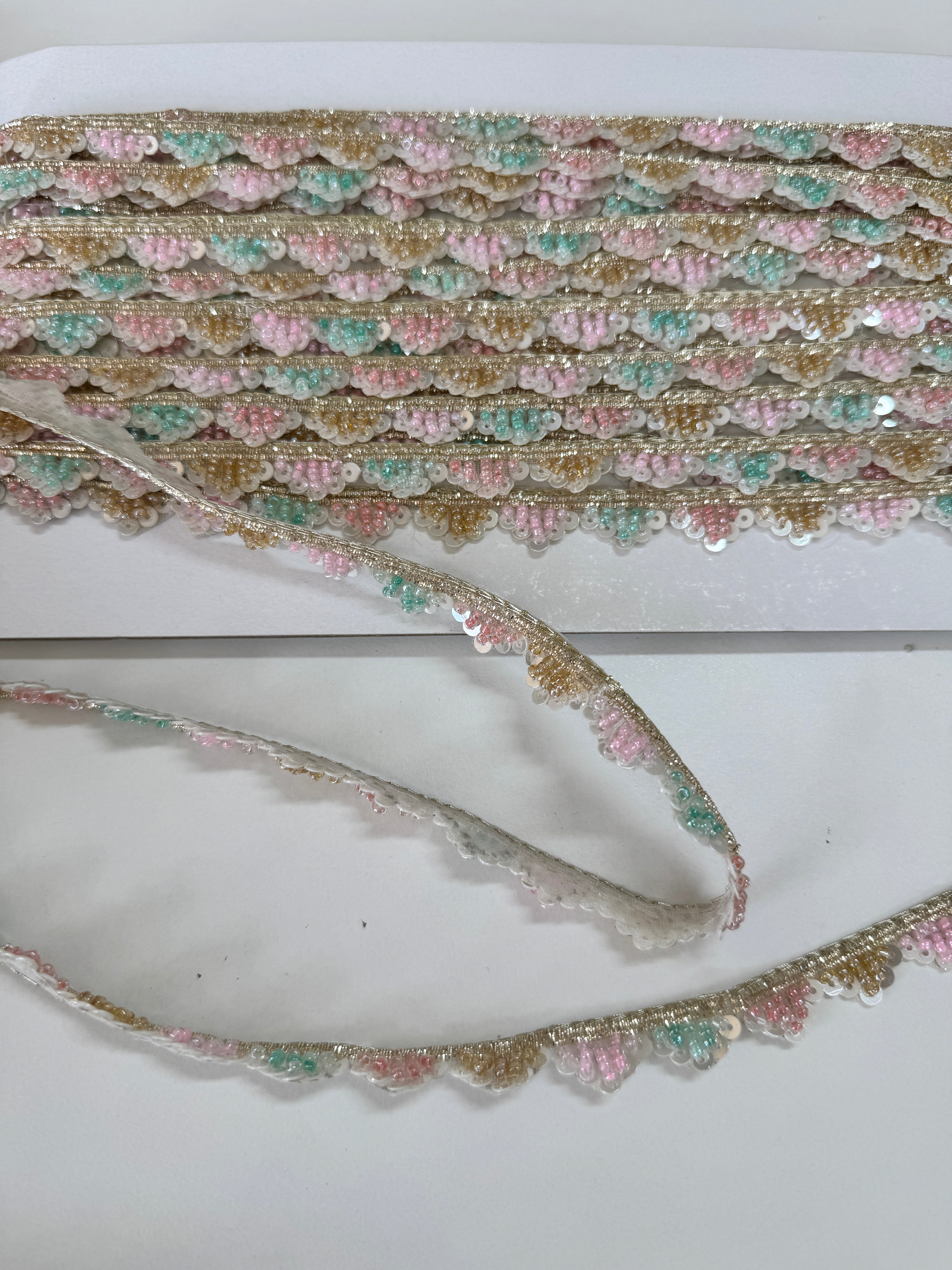 Pastel pink, mint, ivory, and gold beaded sequin trim with metallic edging.