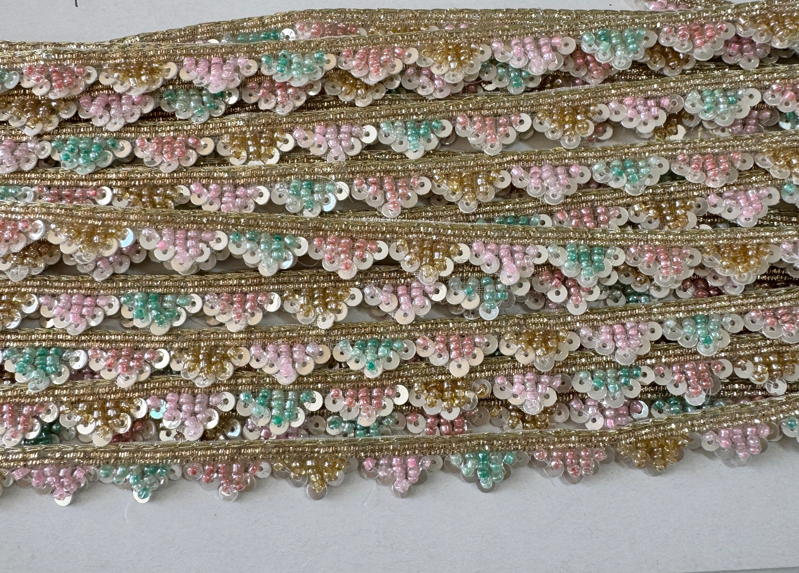 Pastel pink, mint, ivory, and gold beaded sequin trim with metallic edging.