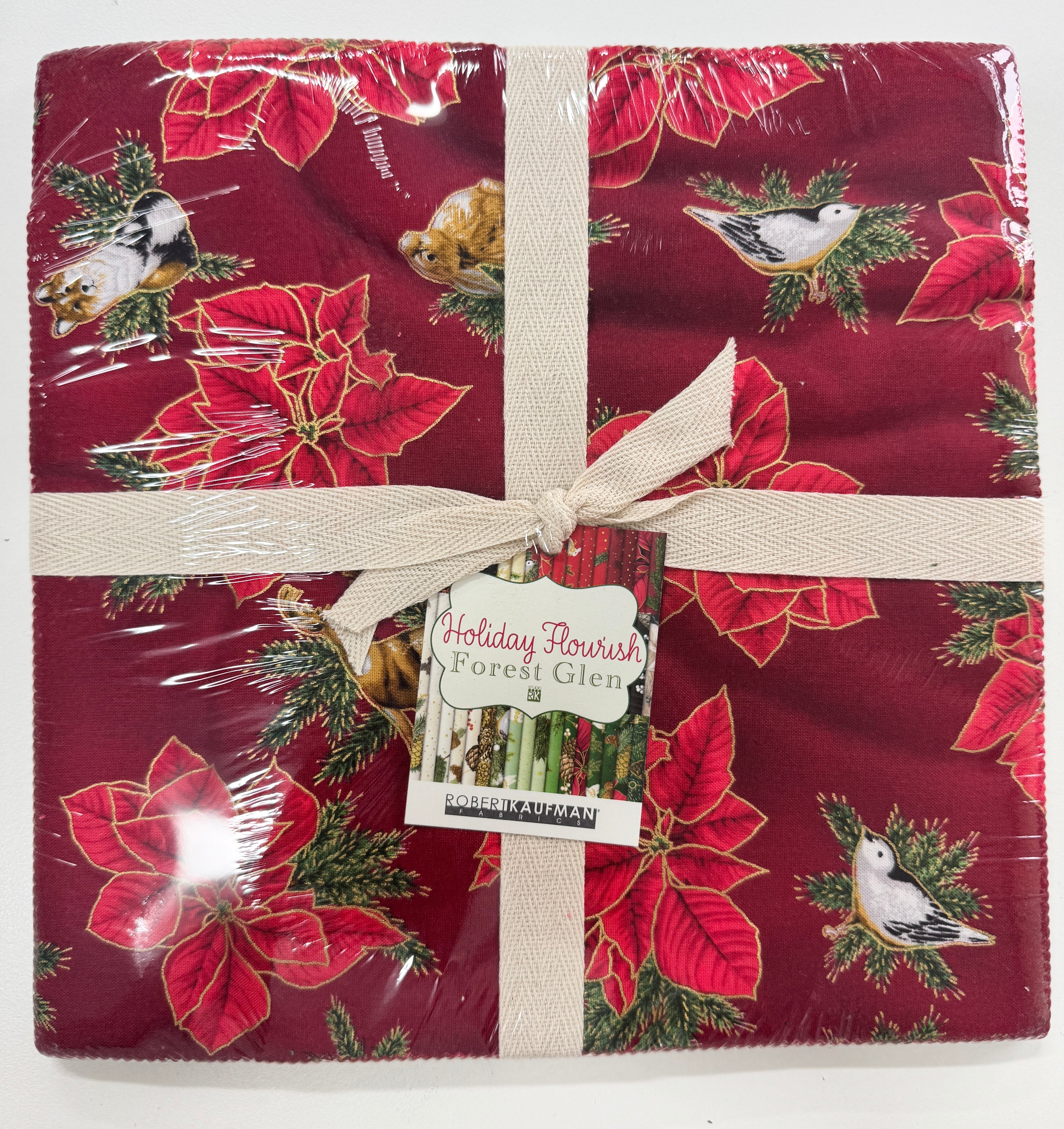 Holiday Flourish Forest Glen Ten Squares precut bundle featuring Christmas fabrics with poinsettias, woodland animals, pinecones, ornaments, evergreens, and metallic gold accents.