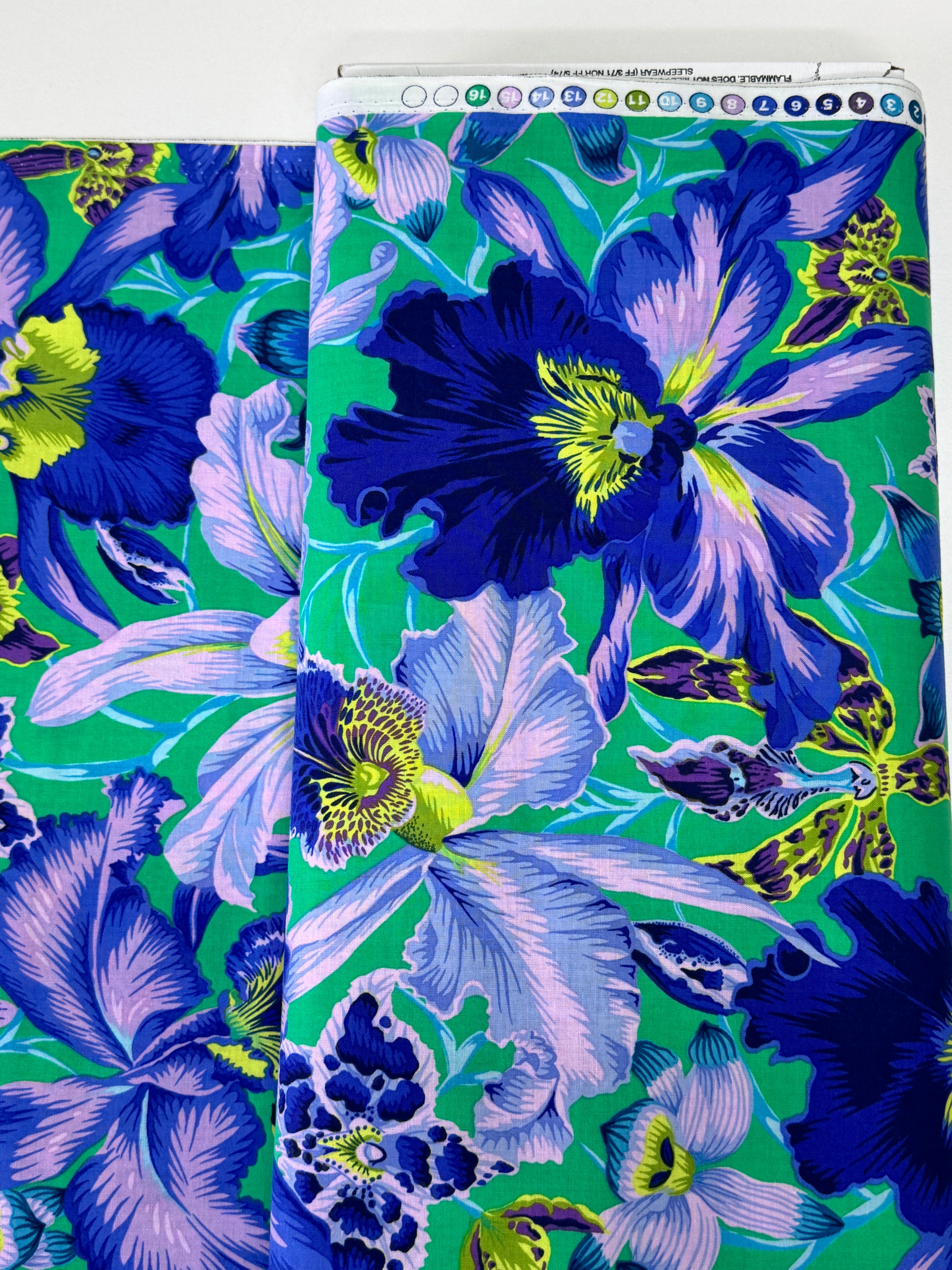 Large blue and lavender orchids with tropical blooms on a vibrant turquoise background, Orchids Blue fabric by Philip Jacobs for FreeSpirit Fabrics.