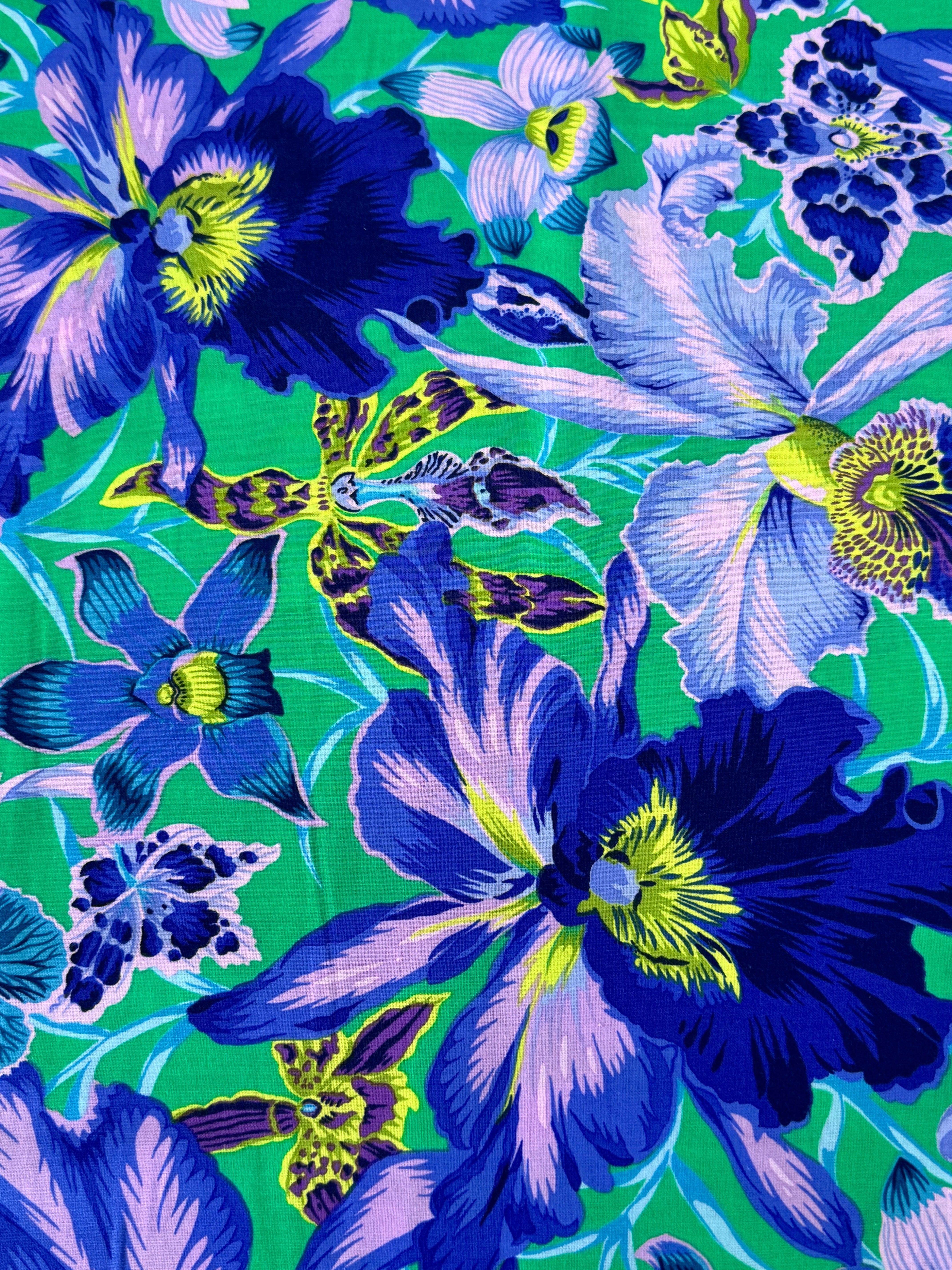 Large blue and lavender orchids with tropical blooms on a vibrant turquoise background, Orchids Blue fabric by Philip Jacobs for FreeSpirit Fabrics.