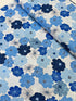 Blue and white flowers with pearlescent shimmer accents scattered across a white background, Packed Shimmer Flower White Pearlescent fabric by Greta Lynn for Kanvas Studio Benartex.