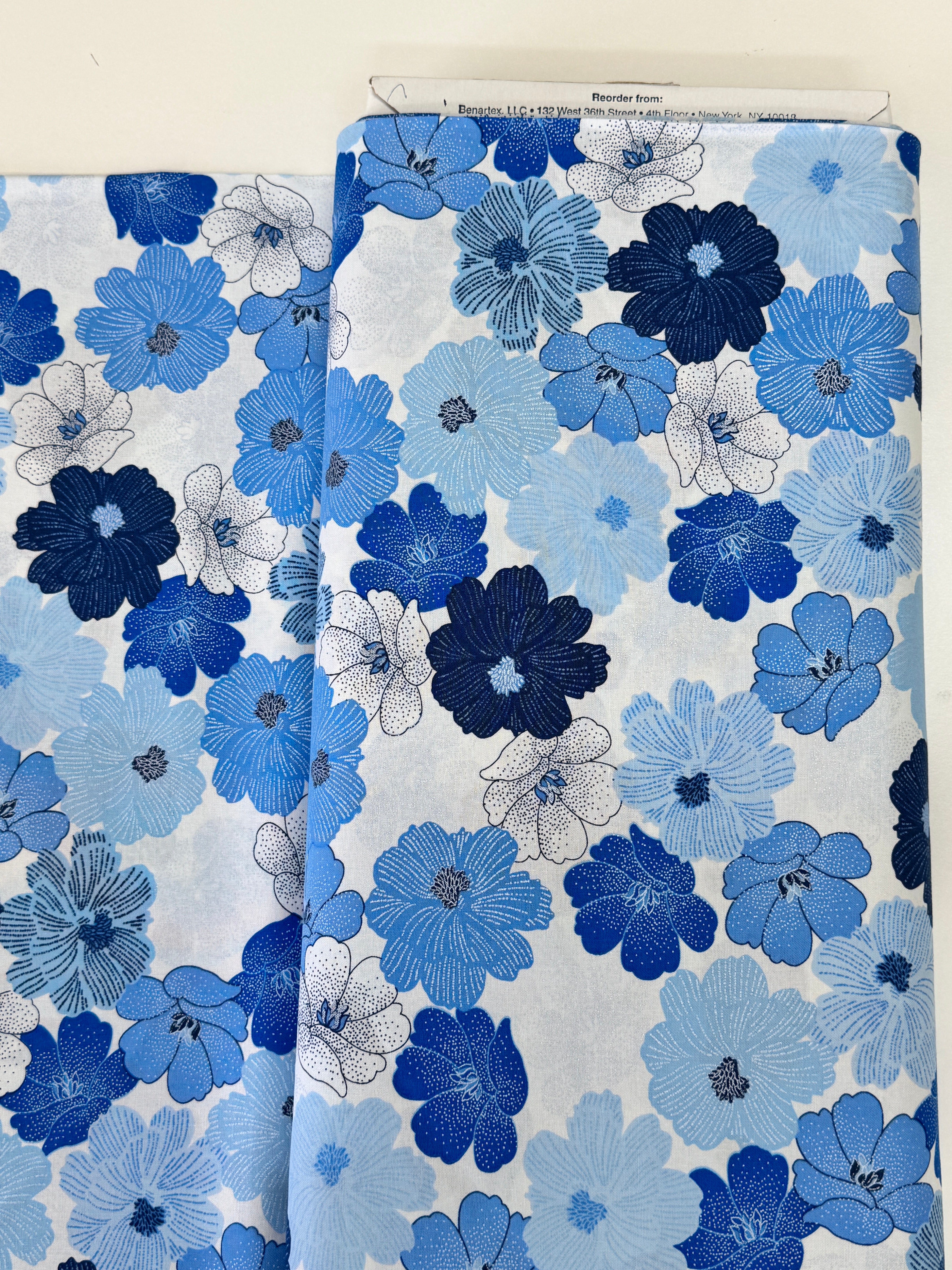 Blue and white flowers with pearlescent shimmer accents scattered across a white background, Packed Shimmer Flower White Pearlescent fabric by Greta Lynn for Kanvas Studio Benartex.