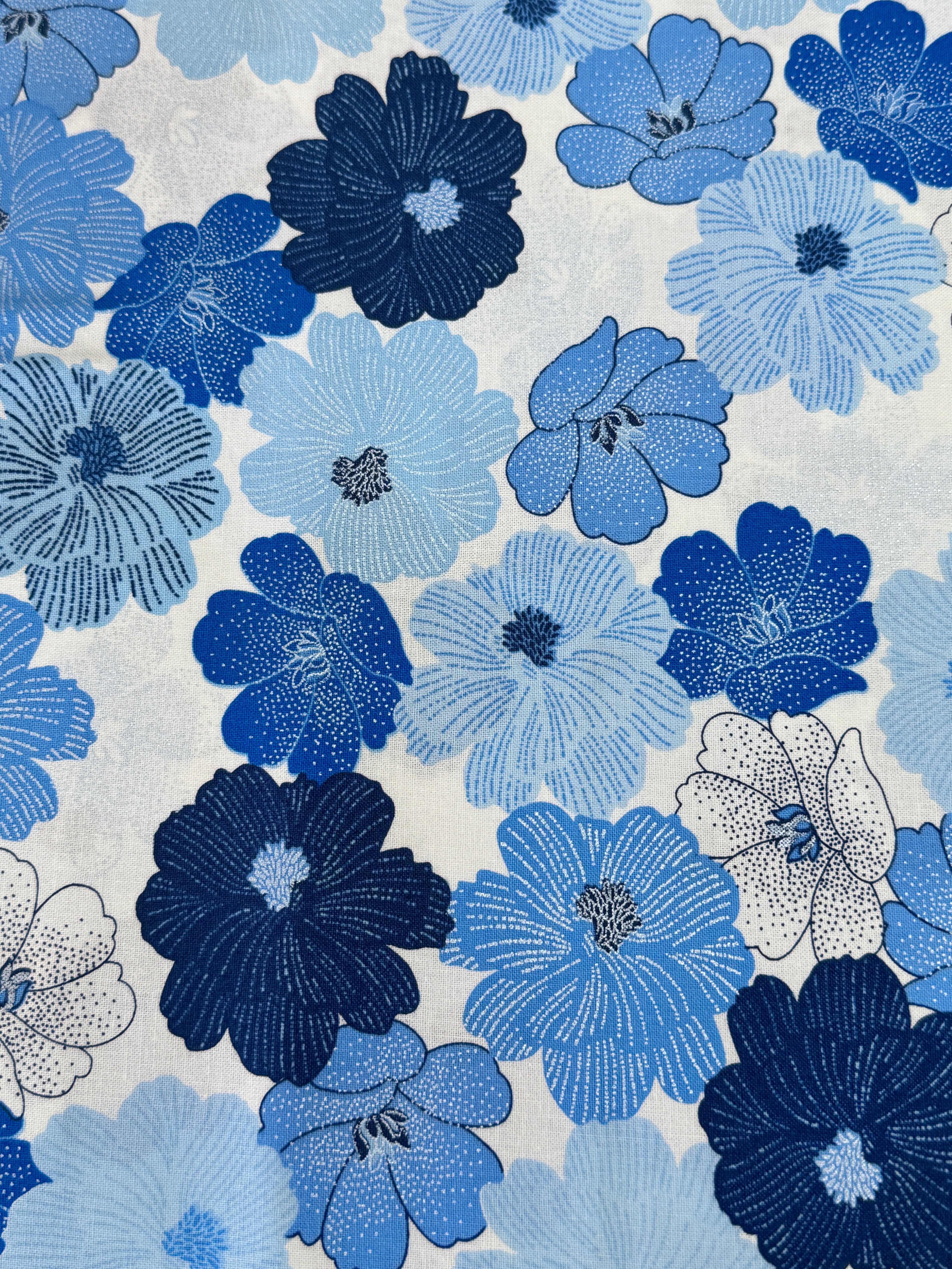 Blue and white flowers with pearlescent shimmer accents scattered across a white background, Packed Shimmer Flower White Pearlescent fabric by Greta Lynn for Kanvas Studio Benartex.