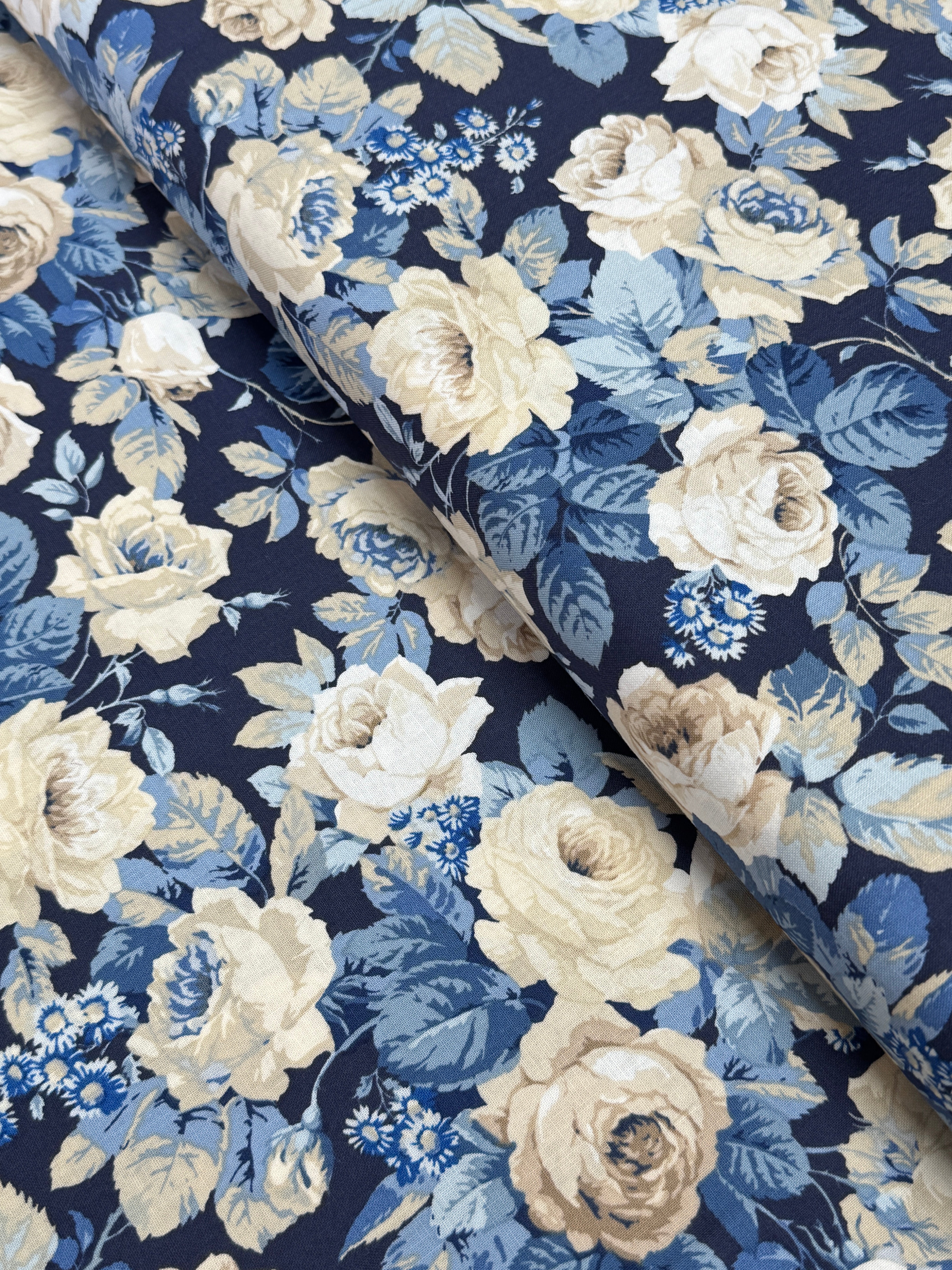 Elegant navy floral cotton fabric with cream roses and soft blue foliage from the Sanderson Vintage Collection by Free Spirit Fabrics.