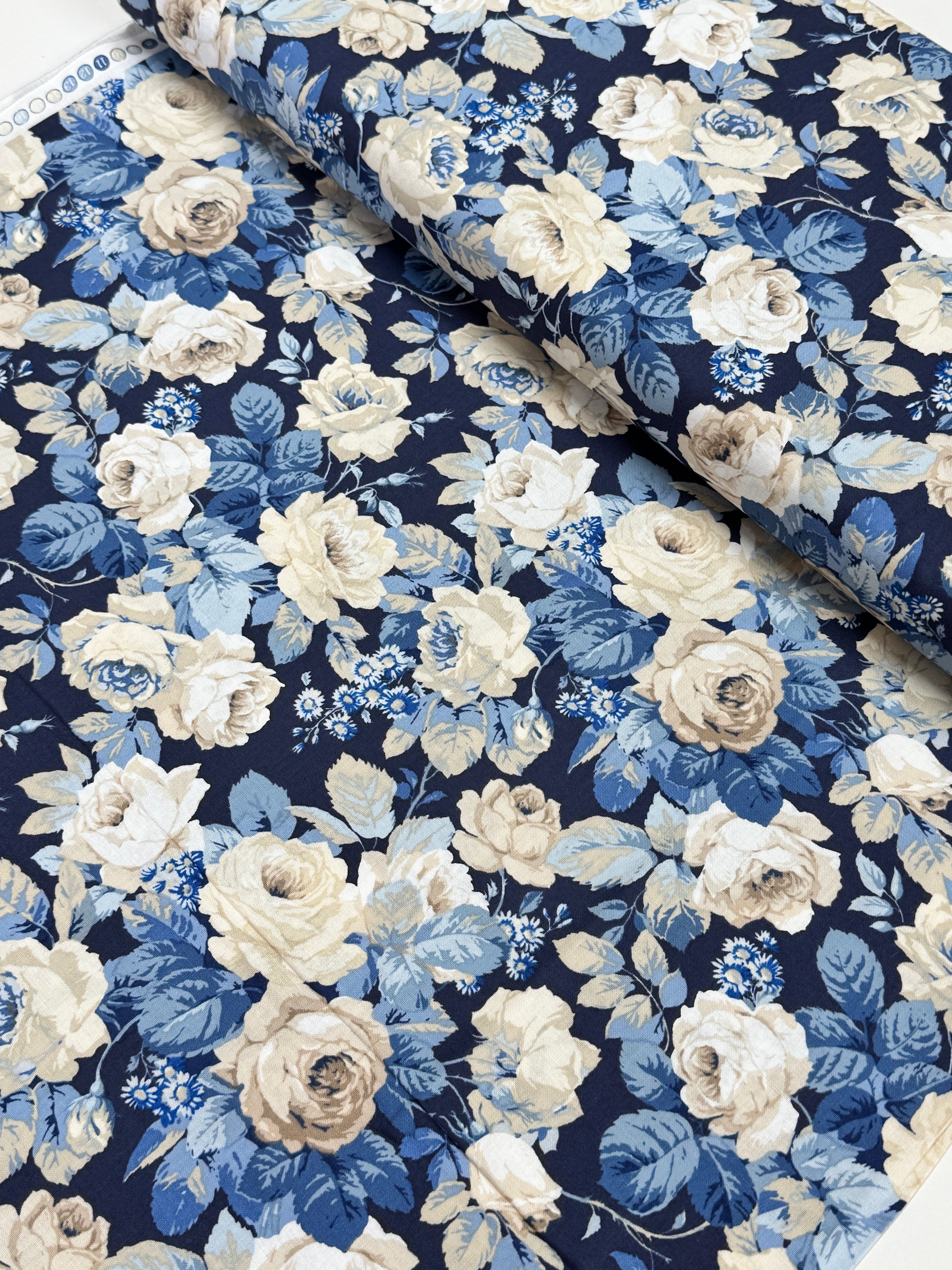Elegant navy floral cotton fabric with cream roses and soft blue foliage from the Sanderson Vintage Collection by Free Spirit Fabrics.