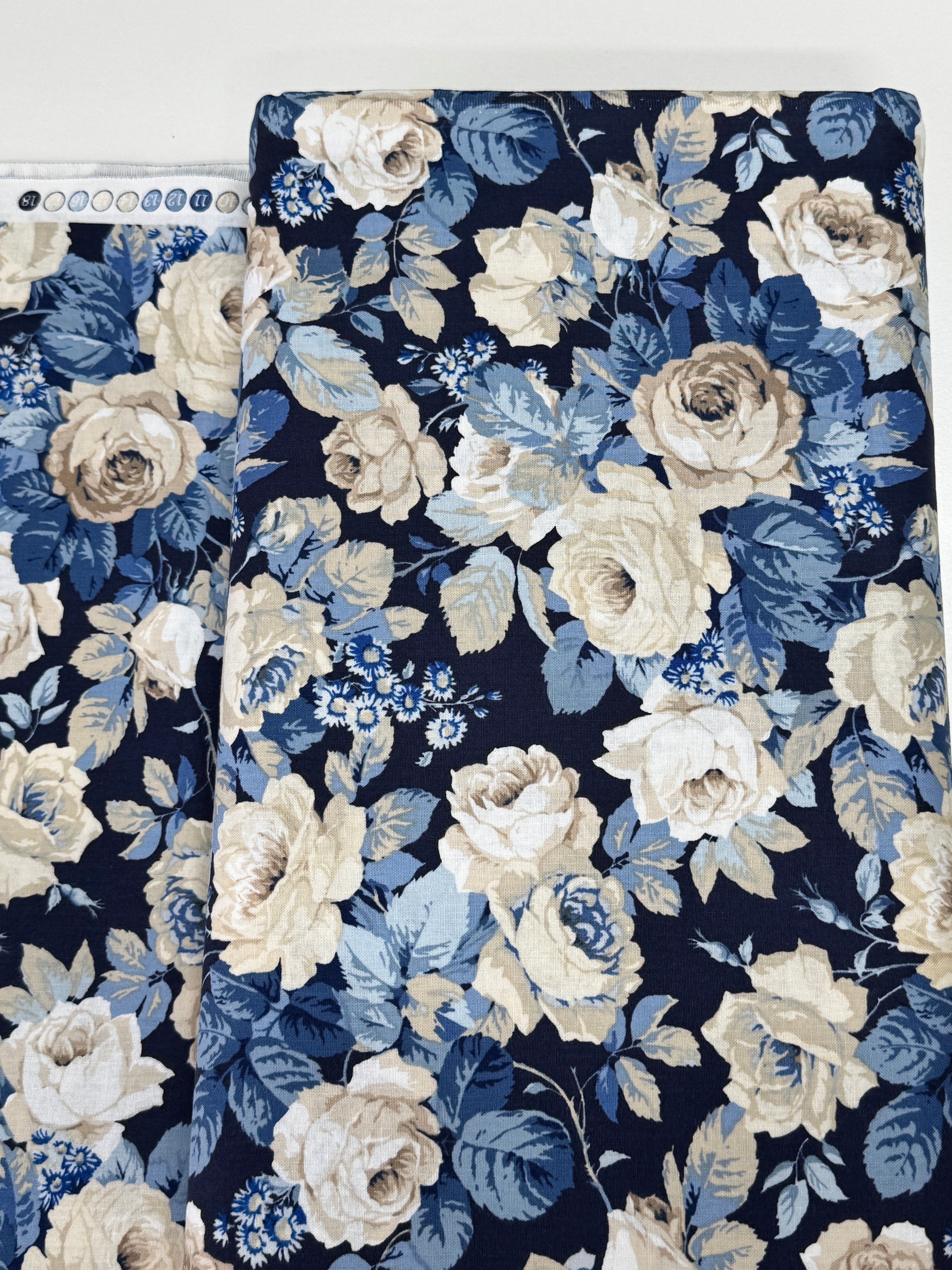 Elegant navy floral cotton fabric with cream roses and soft blue foliage from the Sanderson Vintage Collection by Free Spirit Fabrics.