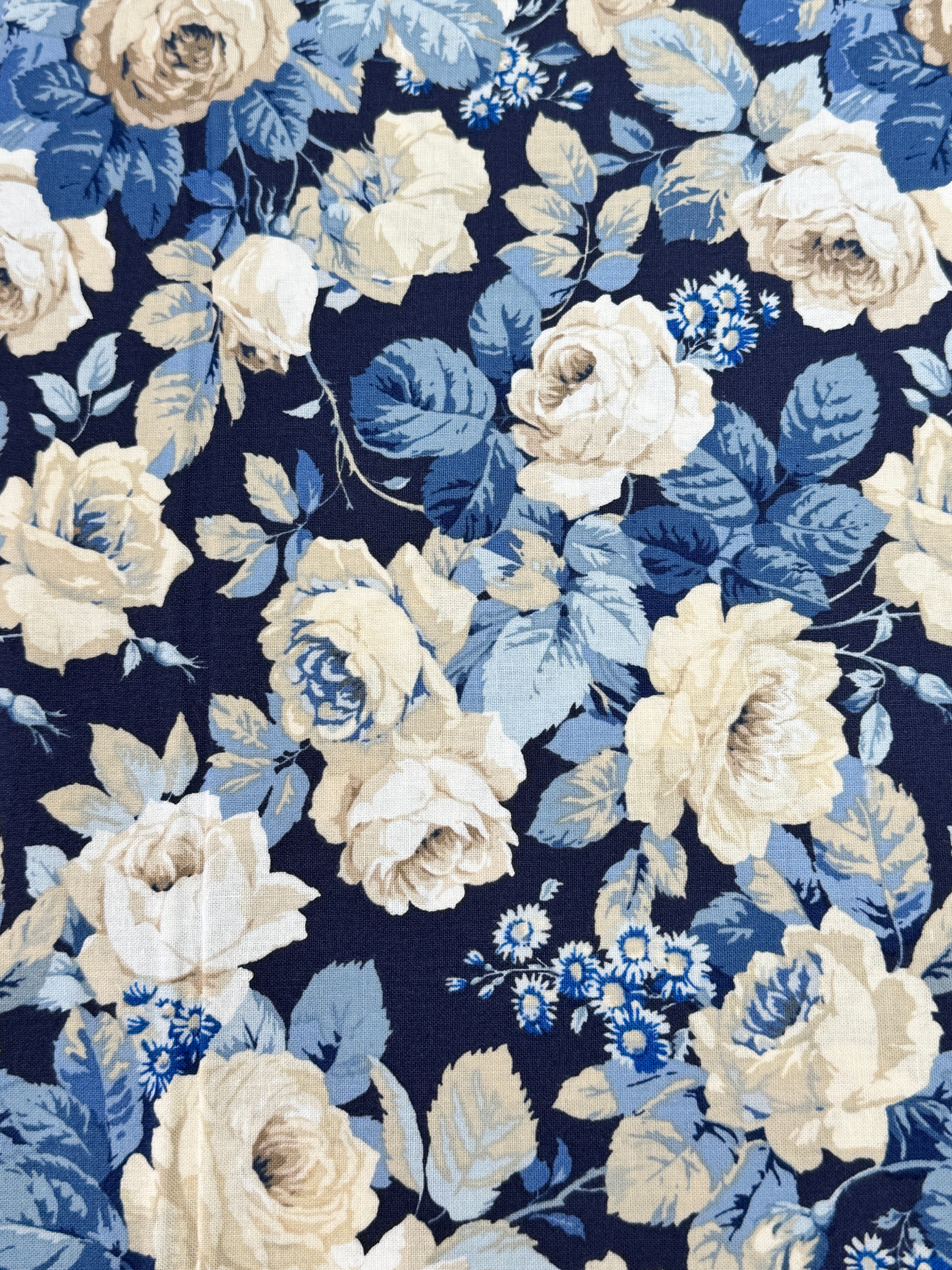 Elegant navy floral cotton fabric with cream roses and soft blue foliage from the Sanderson Vintage Collection by Free Spirit Fabrics.