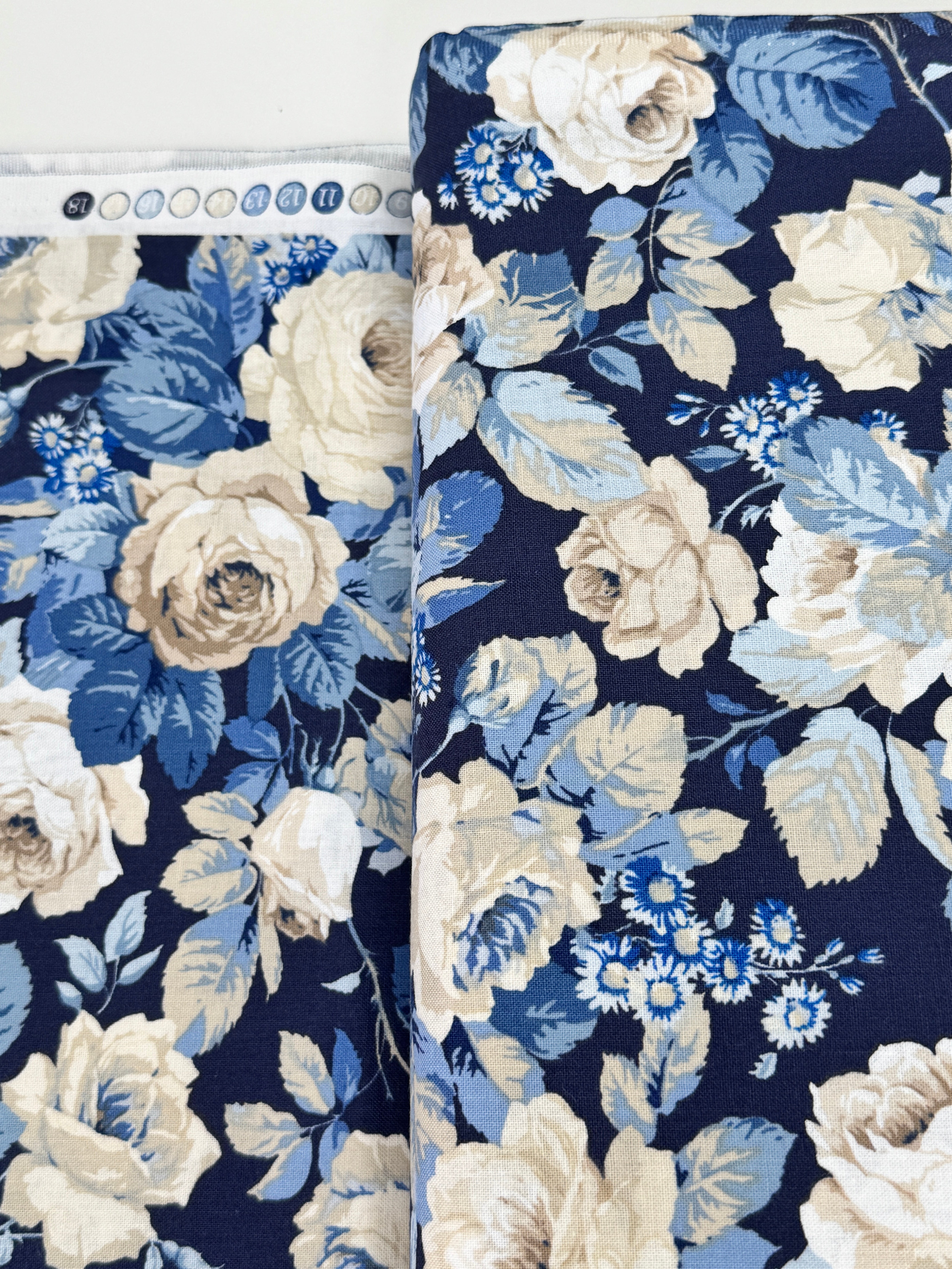 Elegant navy floral cotton fabric with cream roses and soft blue foliage from the Sanderson Vintage Collection by Free Spirit Fabrics.