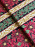 Holiday Flourish 12 poinsettia stripe black metallic fabric featuring red poinsettias, holly leaves, and gold scrollwork by Peggy Toole for Robert Kaufman.