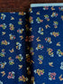 Navy cotton fabric featuring delicate floral blossoms and butterflies scattered throughout, from the Japanese Garden collection by Maywood Studio.
