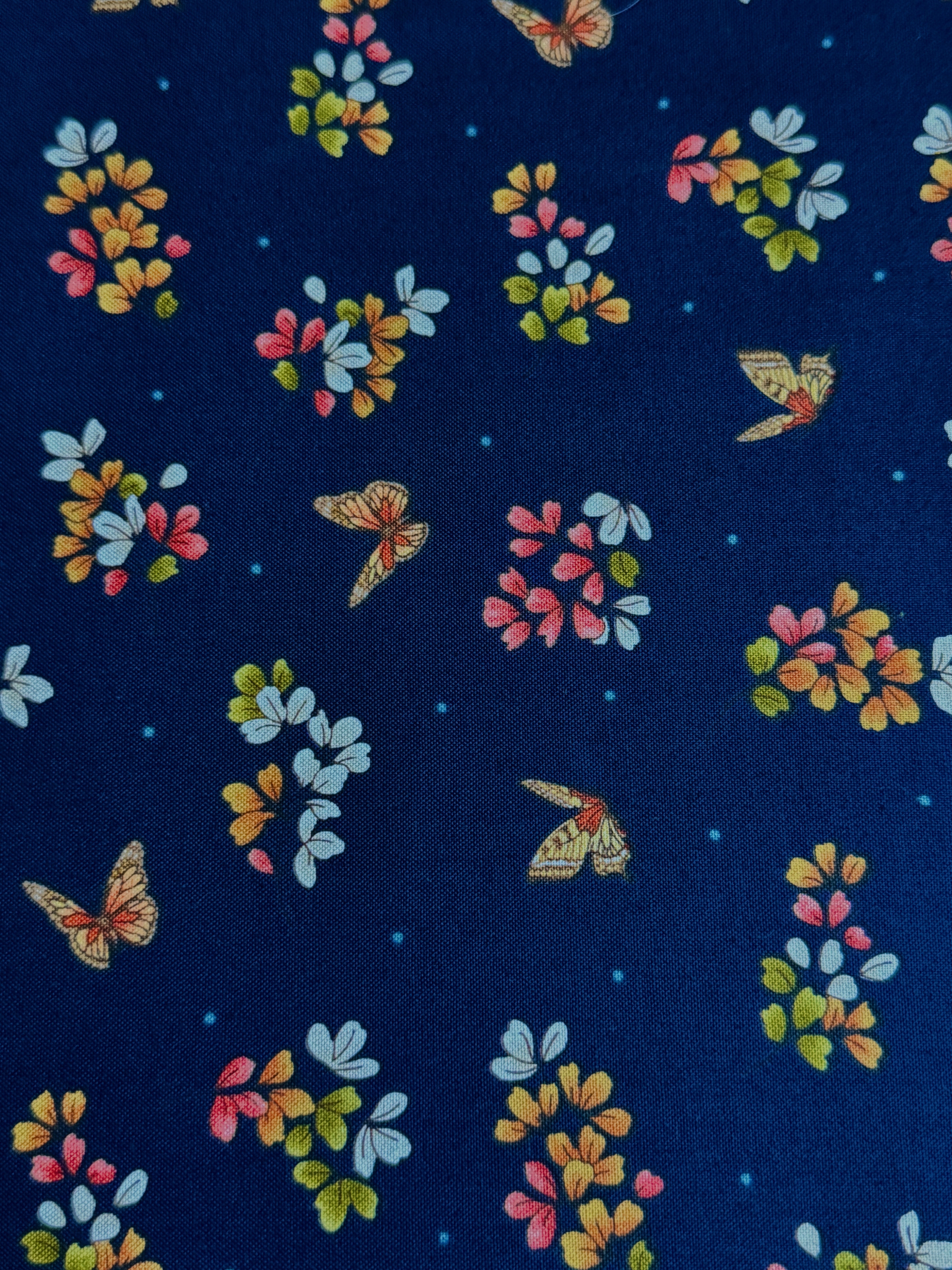 Navy cotton fabric featuring delicate floral blossoms and butterflies scattered throughout, from the Japanese Garden collection by Maywood Studio.