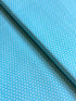 Aqua blue cotton fabric featuring small white polka dots in an all-over pattern by Robert Kaufman Fabrics, ideal for quilting, sewing, nursery décor, and craft projects.