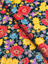 Florentine Garden Floral Multi Metallic cotton fabric by Hyun Joo Lee for Robert Kaufman featuring vibrant red, gold, purple, and blue flowers with metallic accents on a black background.