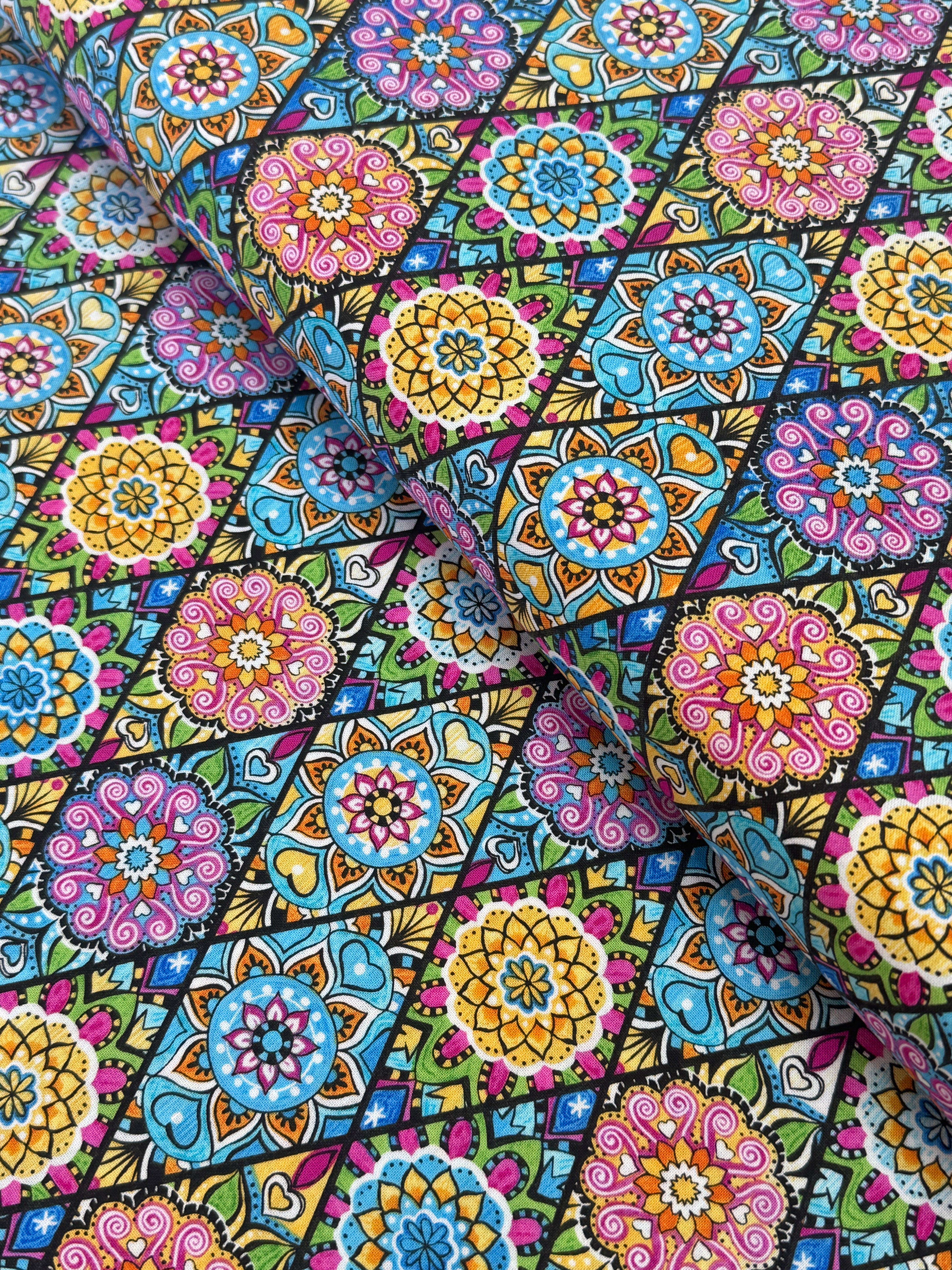 Pink mandala quilting fabric featuring colorful geometric floral medallions in turquoise, aqua, yellow, and lime green by Blank Quilting.