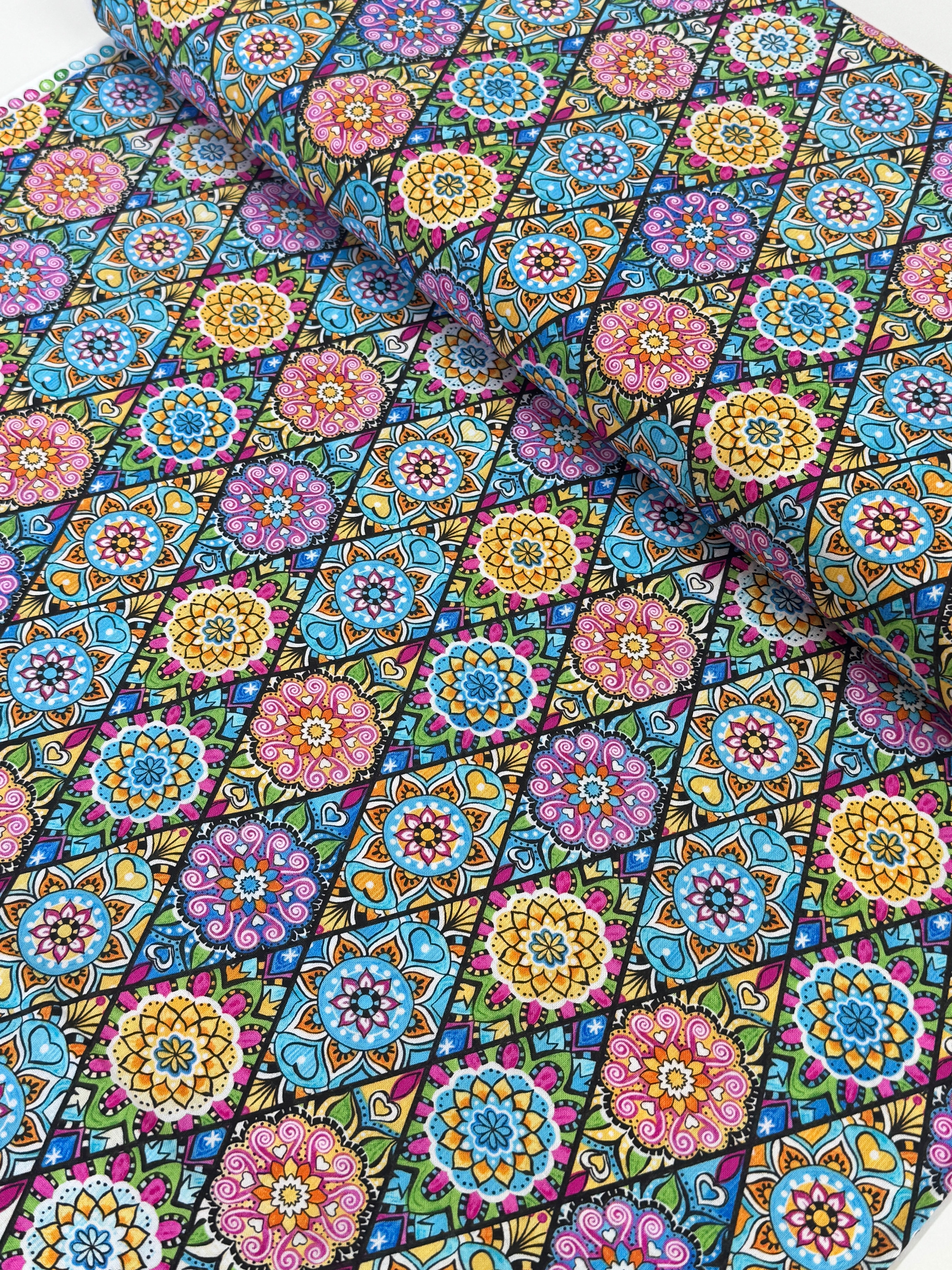 Pink mandala quilting fabric featuring colorful geometric floral medallions in turquoise, aqua, yellow, and lime green by Blank Quilting.