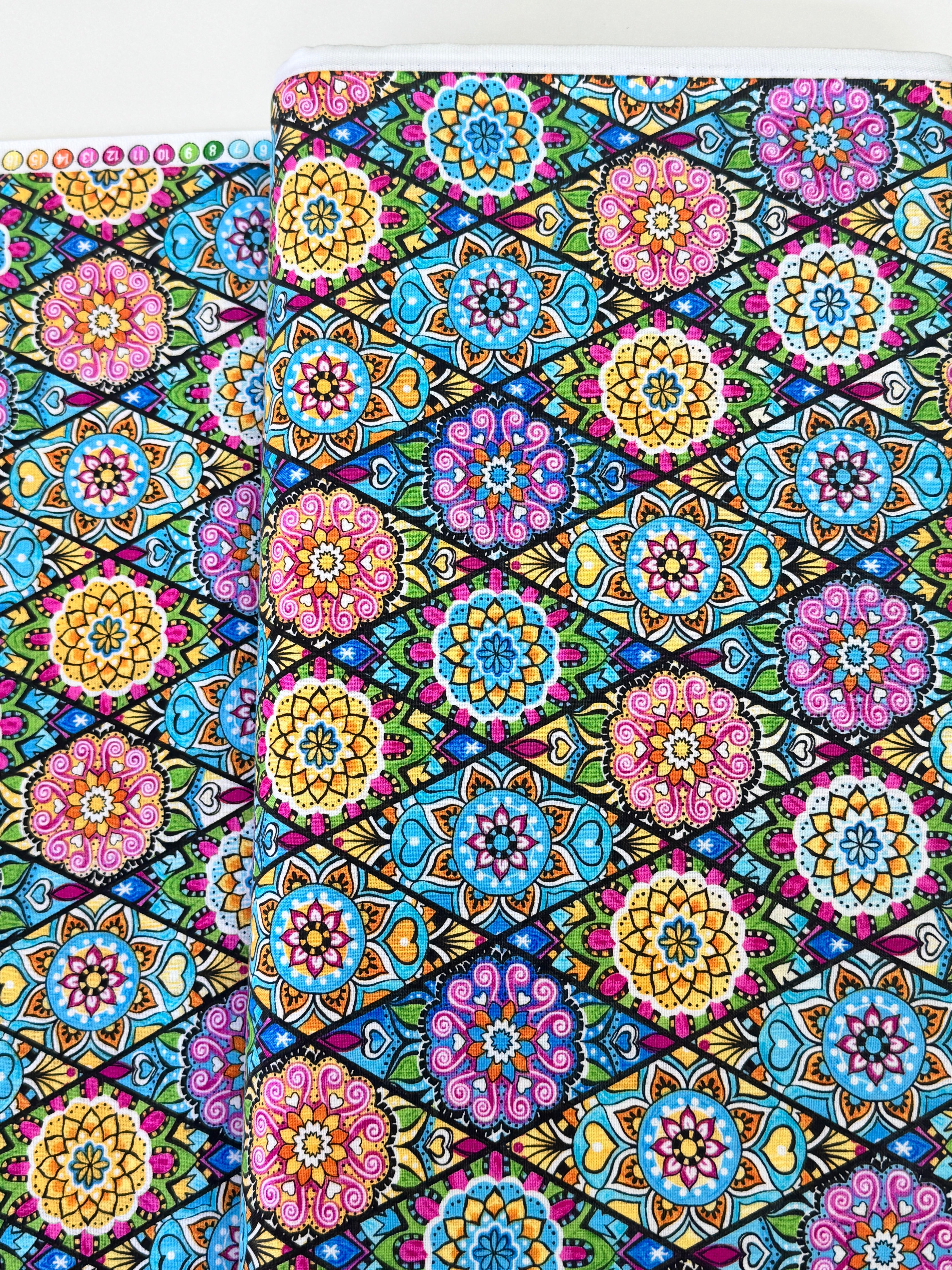 Pink mandala quilting fabric featuring colorful geometric floral medallions in turquoise, aqua, yellow, and lime green by Blank Quilting.