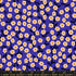 Purple floral fabric with smiling blossoms on blacklight background