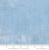 A close-up image of Grunge Cosmic Quilt Back fabric by BasicGrey for Moda Fabrics, featuring a soft light blue color with a subtle textured grunge pattern.