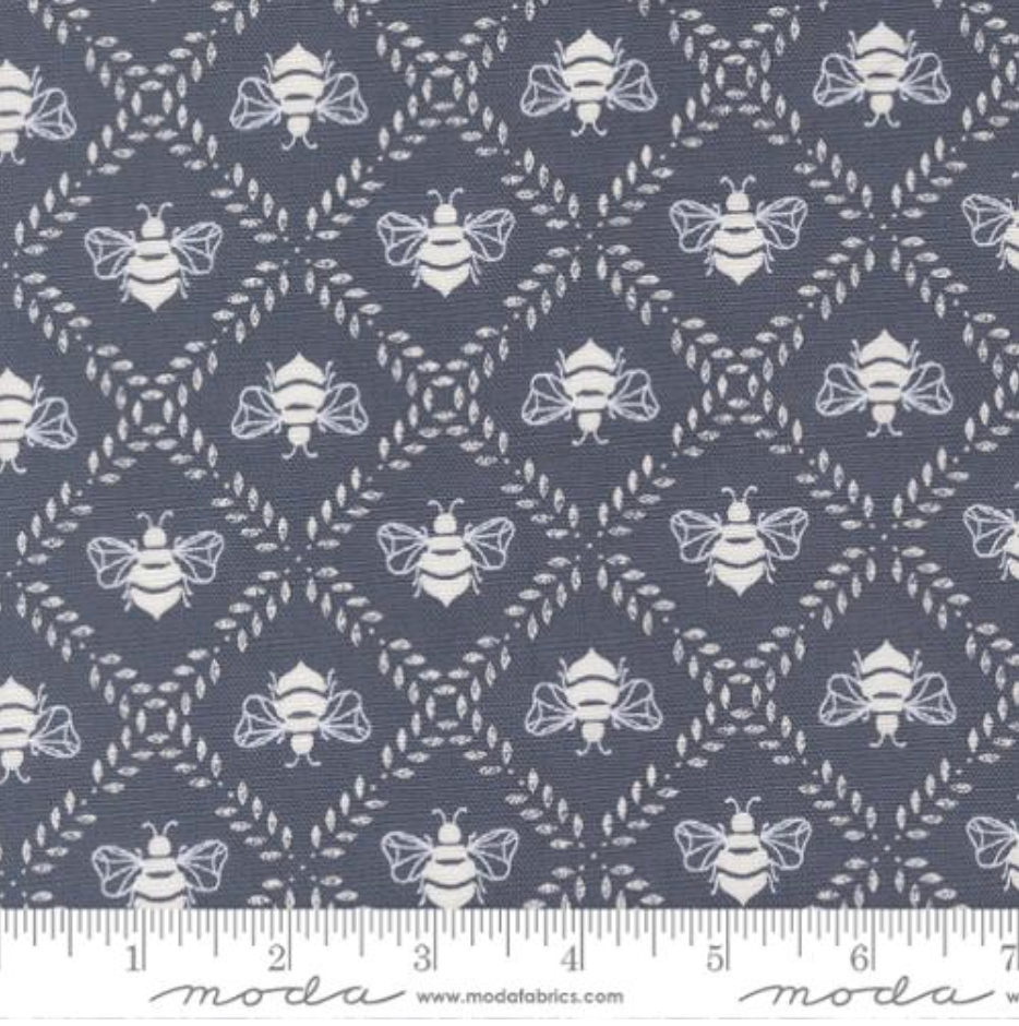 Bees Gathering Honey Indigo cotton canvas fabric by Sweetfire Road for Moda Fabrics showing white bees on dark blue background.