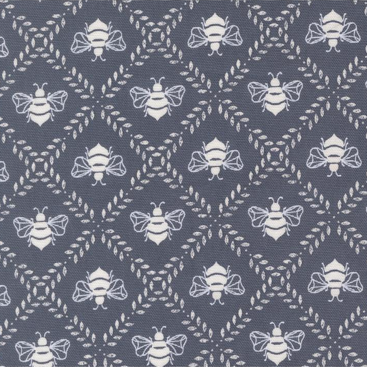 Bees Gathering Honey Indigo cotton canvas fabric by Sweetfire Road for Moda Fabrics showing white bees on dark blue background.