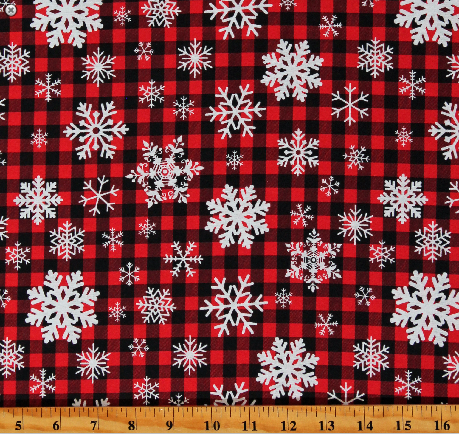 Red and black buffalo plaid cotton fabric with white snowflake pattern
