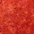 Red and orange batik fabric featuring dahlia-inspired floral bursts by Island Batik.