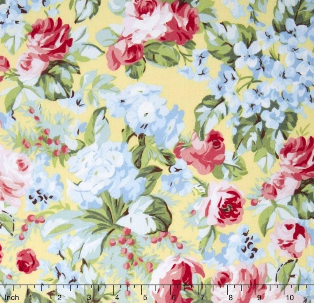 Floral cotton fabric featuring pink roses, blue hydrangeas, and delicate blossoms on a soft butter yellow background from the Simply Chic collection by Anna Stuart for Benartex.