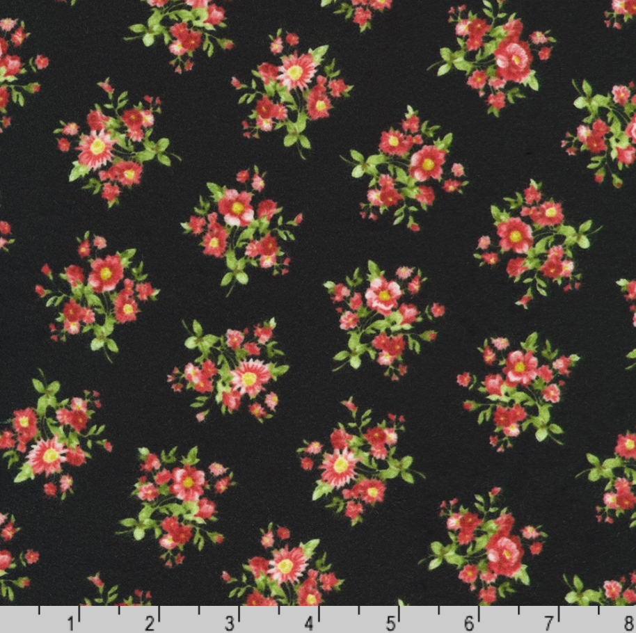 Black cotton flannel featuring scattered pink floral posies from the Bouquet of Roses Flowerhouse Collection by Debbie Beaves for Robert Kaufman.