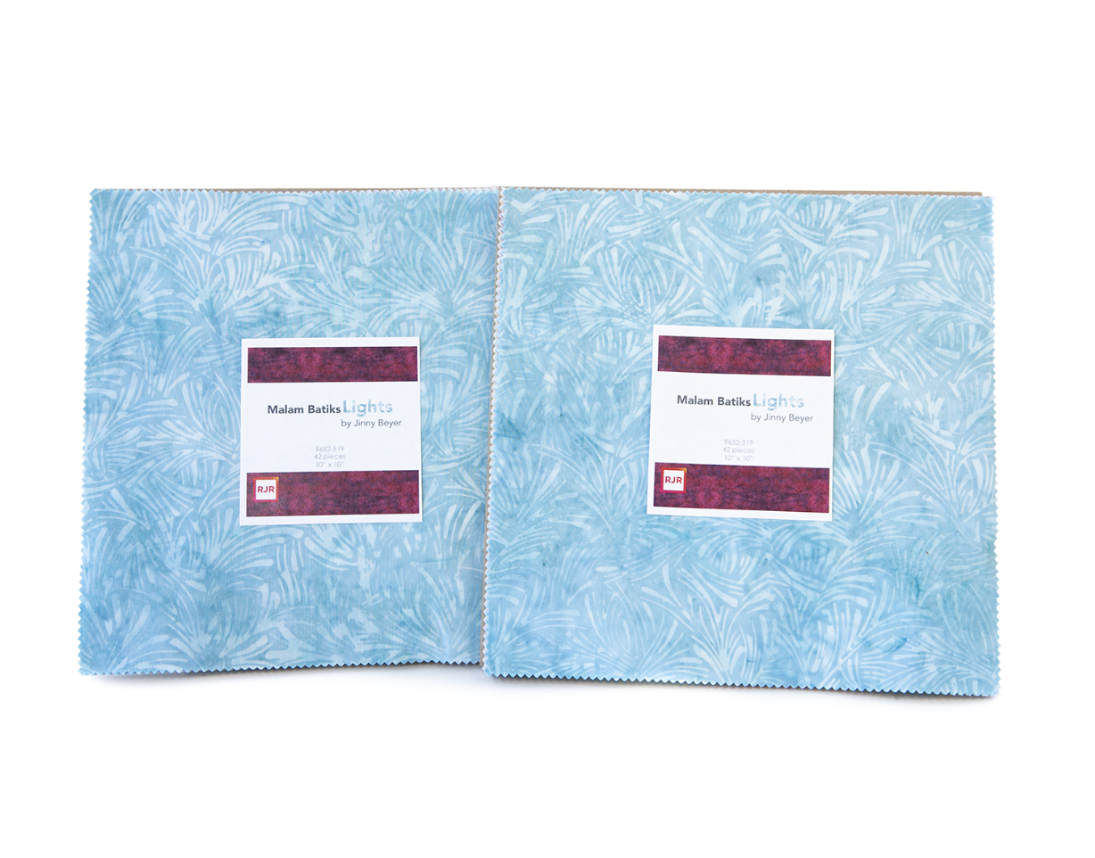 Malam Batiks VI Lights Patty Cake by Jinny Beyer featuring 42 premium 10-inch hand-dyed batik fabric squares in soft blue, aqua, lavender, yellow, pink, and green tones for quilting and sewing.