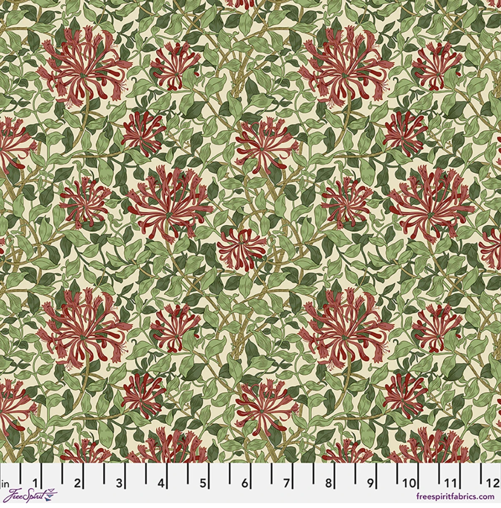 Suffolk Holiday Small Honeysuckle Madder Leaf fabric by Morris & Co, featuring red and rose honeysuckle flowers with layered green leaves on a warm cream background.