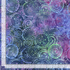Suzani Paradise 108-inch wide batik quilt backing fabric by Timeless Treasures featuring layered circular motifs in purple, violet, blue, teal, green, aqua, and pink.