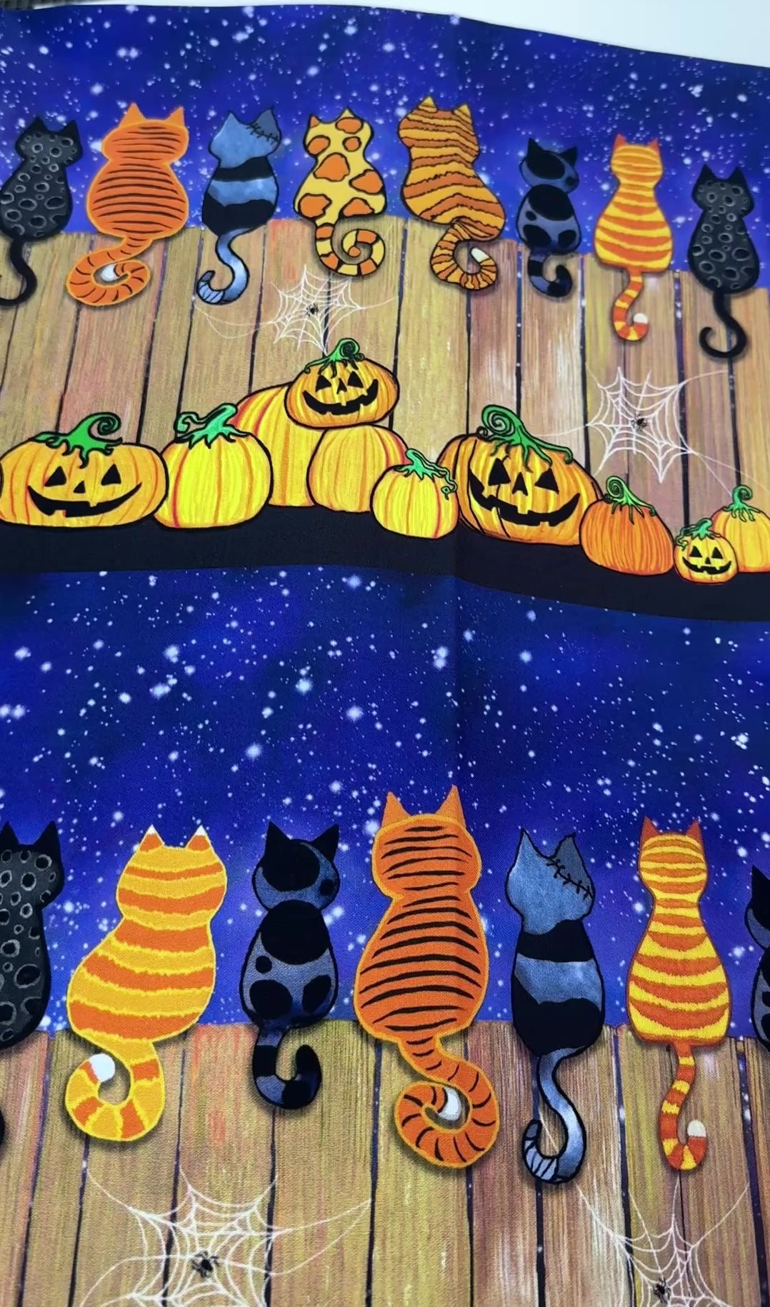 Feline Spooky Cats on Fence cotton fabric by Timeless Treasures featuring colorful Halloween cats, pumpkins, spider webs, and a rustic wooden fence.