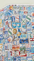 Coastal cotton fabric featuring beach-themed words, seashells, sand dollars, and nautical typography in blue, tan, and white tones.