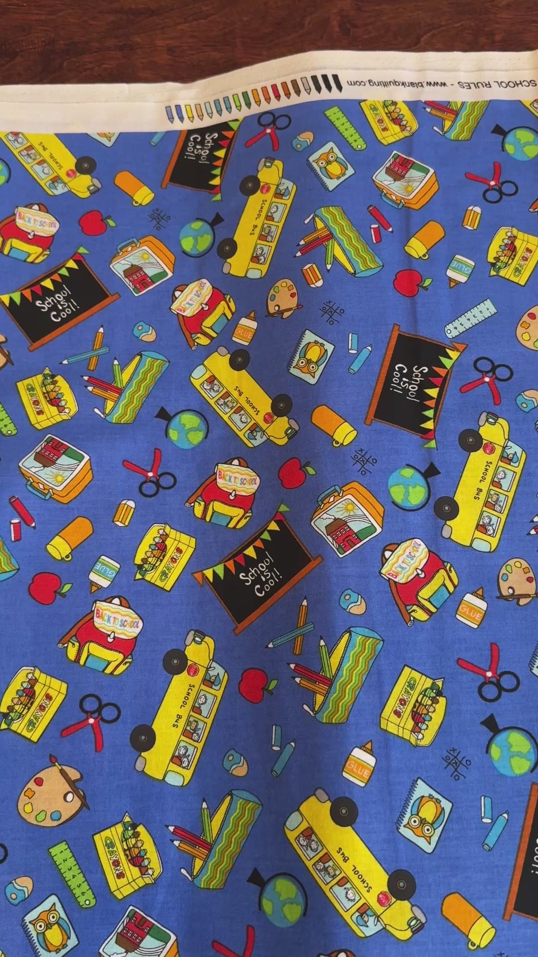 Blue School Rules cotton fabric featuring school buses, crayons, apples, chalkboards and classroom supplies by Blank Quilting.