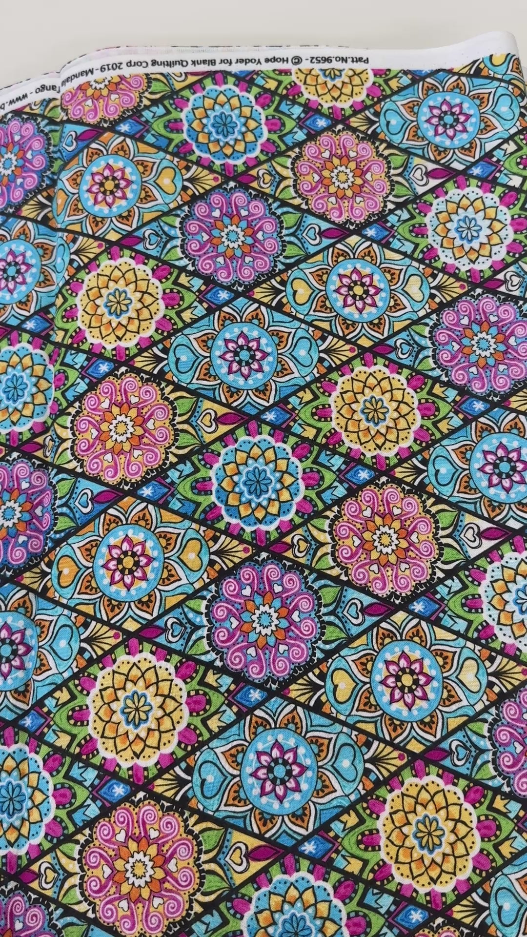 Pink mandala quilting fabric featuring colorful geometric floral medallions in turquoise, aqua, yellow, and lime green by Blank Quilting.